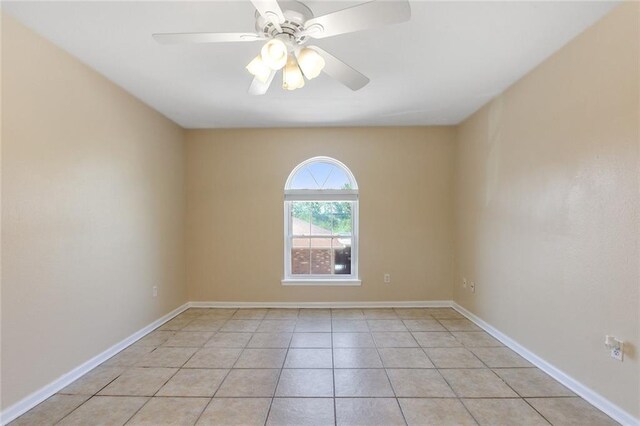 empty room featuring light tile patterned floors, baseboards, and ceiling fan
