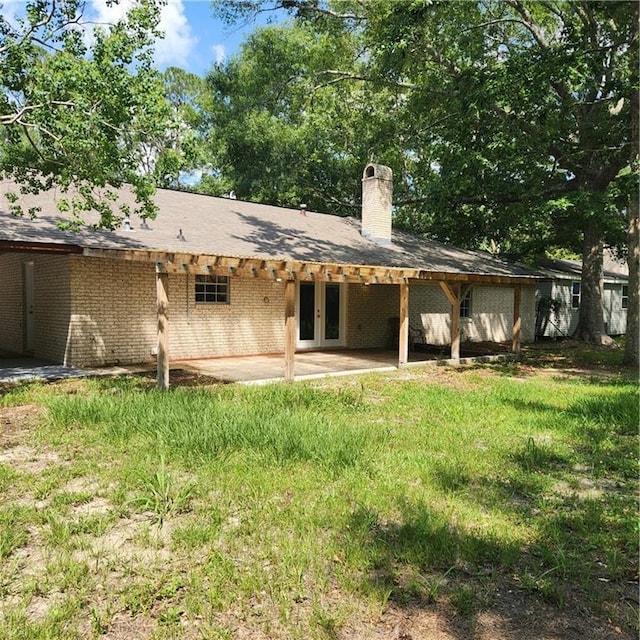 34084 Reilly Rd, Slidell, LA 70460 - rear view of house with a chimney, brick siding, french doors, and a patio area