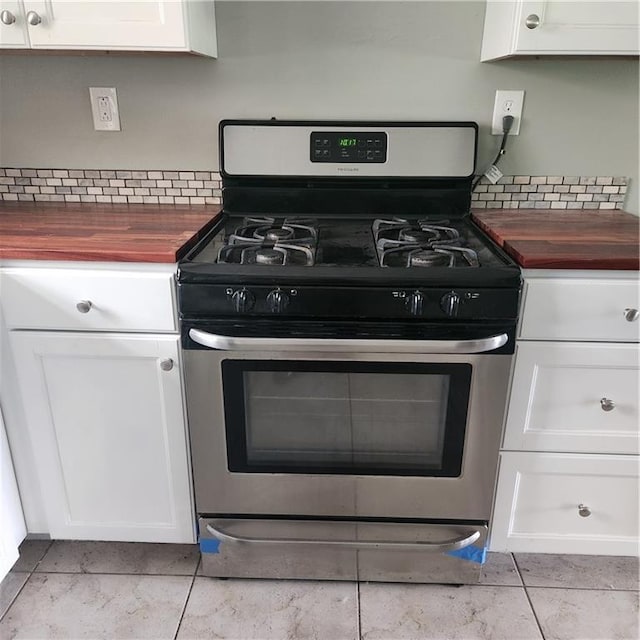 34084 Reilly Rd, Slidell, LA 70460 - details featuring stainless steel range with gas stovetop, wood counters, backsplash, and white cabinets