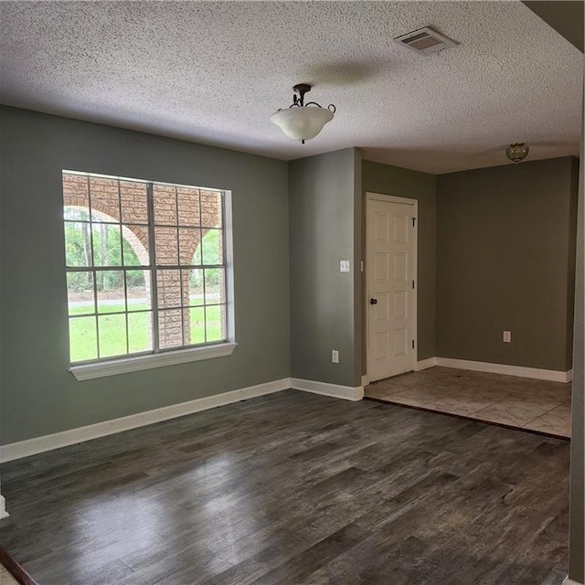 34084 Reilly Rd, Slidell, LA 70460 - spare room featuring dark wood-type flooring, visible vents, baseboards, and a textured ceiling