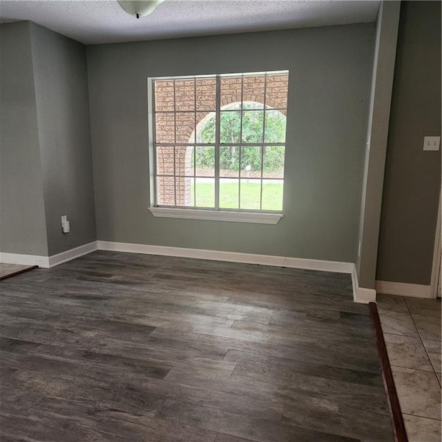 34084 Reilly Rd, Slidell, LA 70460 - spare room with a textured ceiling, dark wood-style flooring, and baseboards