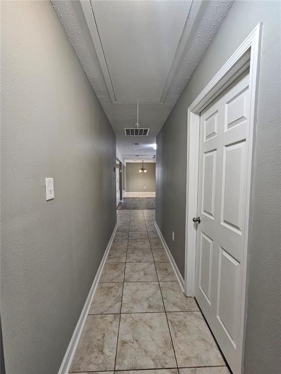 34084 Reilly Rd, Slidell, LA 70460 - corridor featuring attic access, visible vents, marble finish floor, and baseboards