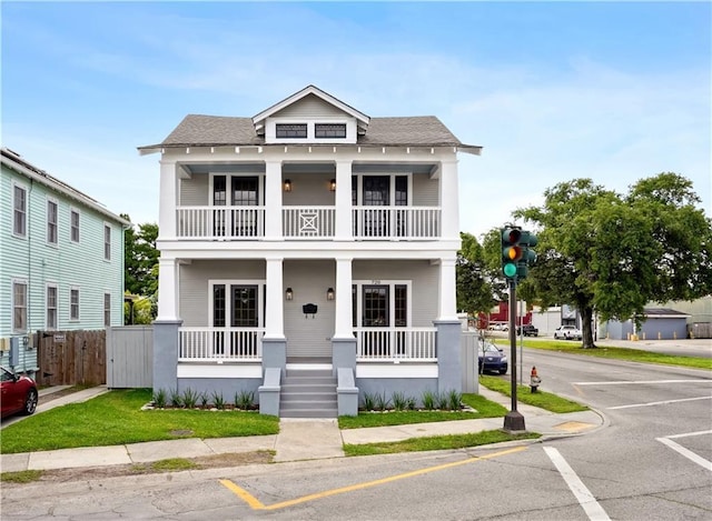 720 Moss St, New Orleans, LA 70119 - view of front of house featuring a balcony, a porch, fence, and a shingled roof