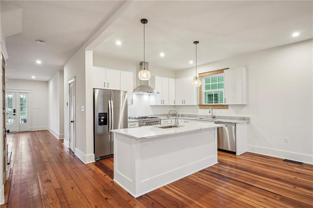 720 Moss St, New Orleans, LA 70119 - kitchen featuring appliances with stainless steel finishes, wall chimney exhaust hood, a sink, white cabinets, and recessed lighting