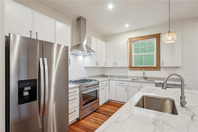720 Moss St, New Orleans, LA 70119 - kitchen featuring stainless steel appliances, wall chimney range hood, a sink, light stone counters, and recessed lighting