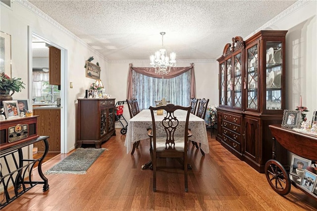430 Holmes Dr, Slidell, LA 70460 - dining space with an inviting chandelier, crown molding, wood finished floors, and a textured ceiling