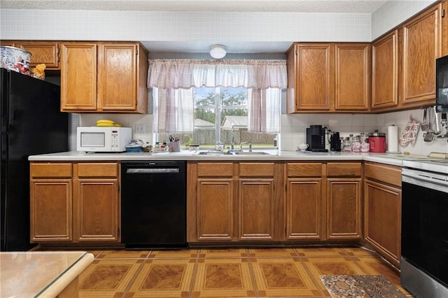 430 Holmes Dr, Slidell, LA 70460 - kitchen featuring light countertops, a sink, brown cabinets, and black appliances