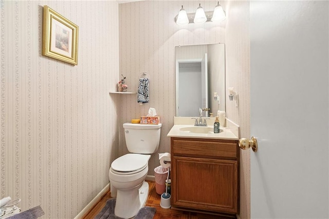 430 Holmes Dr, Slidell, LA 70460 - bathroom featuring toilet, vanity, wood finished floors, and wallpapered walls