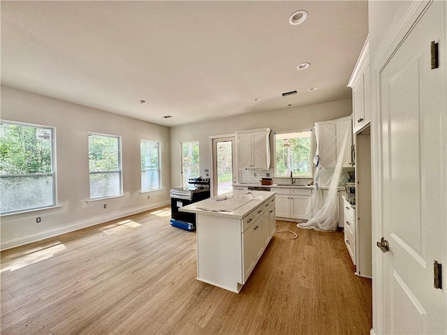 20326 Quincy Ave, Covington, LA 70433 - kitchen with a center island, light wood-type flooring, white cabinets, recessed lighting, and light countertops