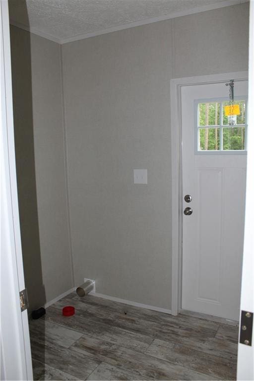 laundry room with baseboards, crown molding, and wood finished floors