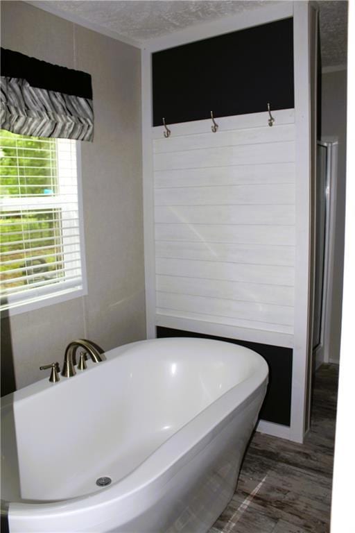 bathroom with a soaking tub and a textured ceiling