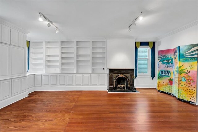1704 Milan St, New Orleans, LA 70115 - unfurnished living room with ornamental molding, rail lighting, wood finished floors, and a fireplace with raised hearth