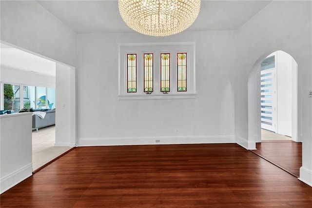1704 Milan St, New Orleans, LA 70115 - unfurnished dining area featuring arched walkways, wood finished floors, a chandelier, and baseboards