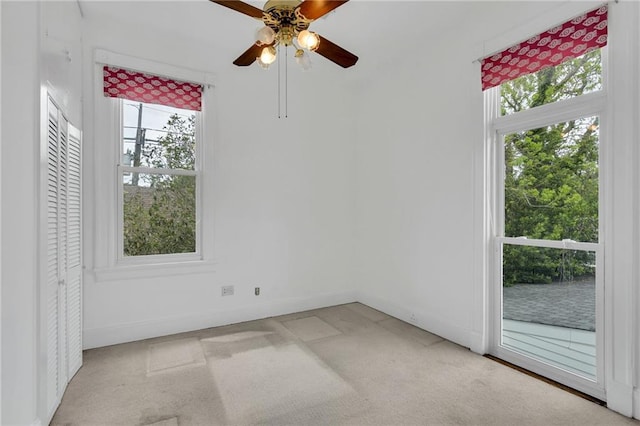 1704 Milan St, New Orleans, LA 70115 - spare room featuring baseboards, a ceiling fan, a wealth of natural light, and light colored carpet