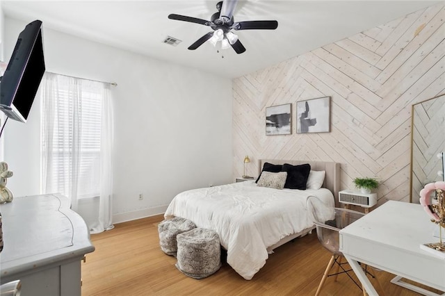 544 Belle Pointe Loop, Madisonville, LA 70447 - bedroom with an accent wall, wood finished floors, visible vents, and baseboards