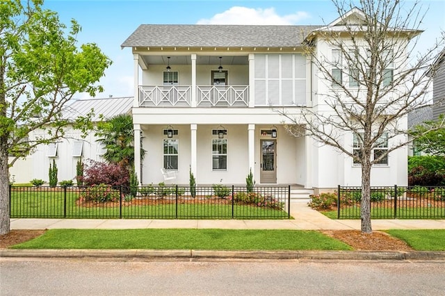 640 Bocage Ct N, Covington, LA 70433 - view of front facade featuring a porch, a balcony, stucco siding, a fenced front yard, and roof with shingles