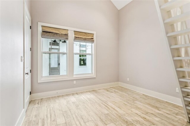 spare room featuring baseboards and light wood-style floors