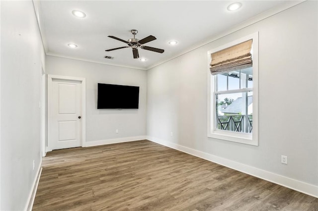 empty room featuring baseboards, recessed lighting, ornamental molding, and wood finished floors