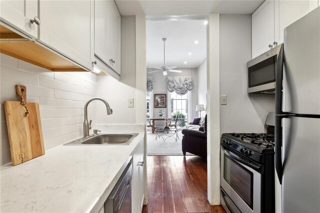 931 Chartres Street 13&14, New Orleans, LA 70116 - kitchen featuring white cabinets, dark wood-style floors, stainless steel appliances, and a sink