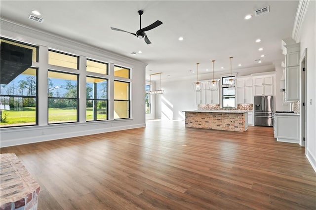 unfurnished living room featuring visible vents, ceiling fan, crown molding, and dark wood finished floors