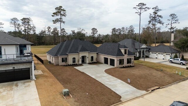 view of front of home with a shingled roof, a front lawn, concrete driveway, and an attached garage