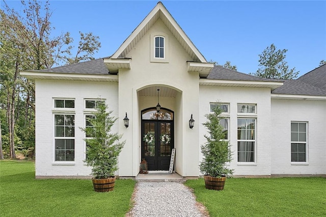 16202 W Bennett Rd, Loranger, LA 70446 - entrance to property featuring french doors, roof with shingles, a lawn, and stucco siding