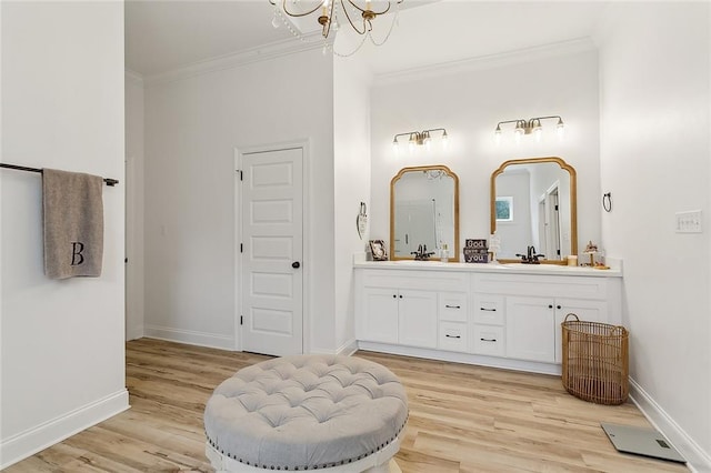 16202 W Bennett Rd, Loranger, LA 70446 - bathroom featuring crown molding, a chandelier, wood finished floors, double vanity, and baseboards