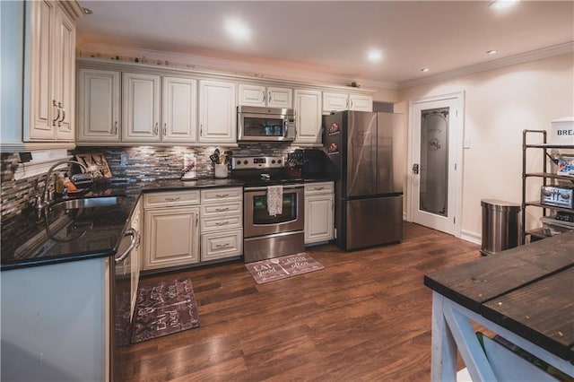 5613 W Esplanade Ave, Metairie, LA 70003 - kitchen with dark wood-style floors, a sink, tasteful backsplash, appliances with stainless steel finishes, and ornamental molding