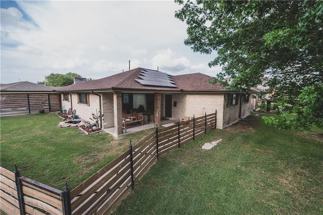 5613 W Esplanade Ave, Metairie, LA 70003 - rear view of property with roof mounted solar panels, a fenced backyard, a yard, and a patio