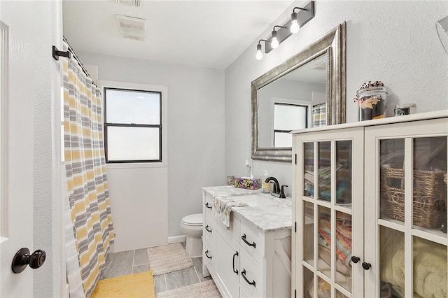 full bath featuring a shower with shower curtain, visible vents, toilet, and vanity