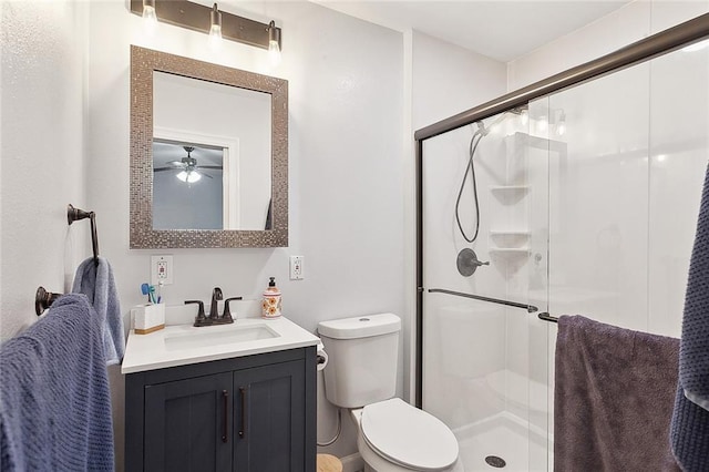 bathroom with a stall shower, a ceiling fan, vanity, and toilet