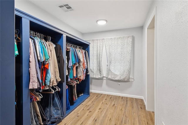 walk in closet with wood finished floors and visible vents