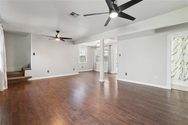 unfurnished living room featuring dark wood finished floors, stairway, visible vents, and ceiling fan