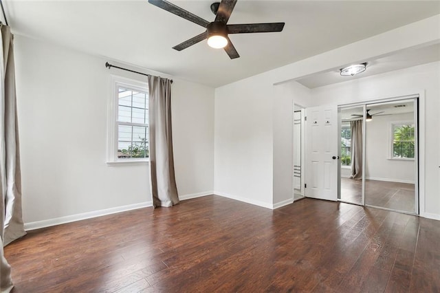 unfurnished bedroom featuring hardwood / wood-style flooring, baseboards, a closet, and a ceiling fan