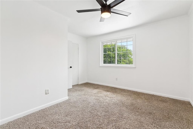carpeted spare room with baseboards and ceiling fan