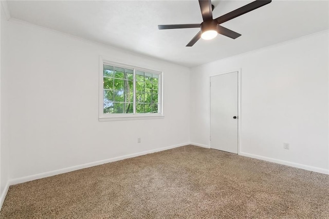 spare room with a ceiling fan, baseboards, carpet, and crown molding