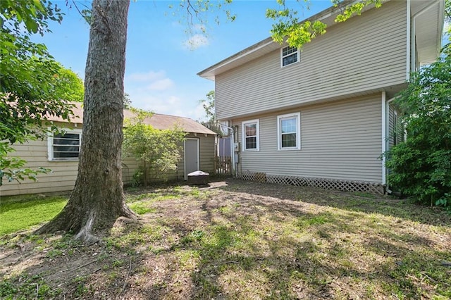 back of house featuring a lawn and fence