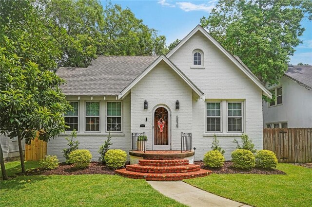 5839 Vicksburg St, New Orleans, LA 70124 - view of front of property with fence, a shingled roof, a front lawn, and brick siding
