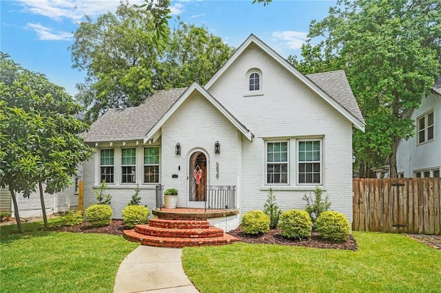 5839 Vicksburg St, New Orleans, LA 70124 - view of front facade featuring brick siding, a front lawn, and fence