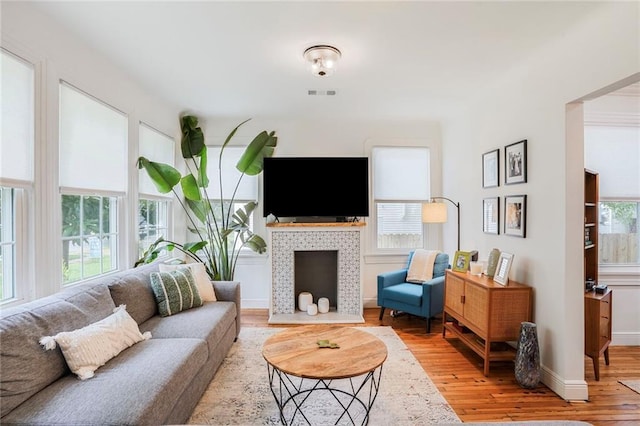5839 Vicksburg St, New Orleans, LA 70124 - living area with light wood-type flooring, baseboards, visible vents, and a fireplace