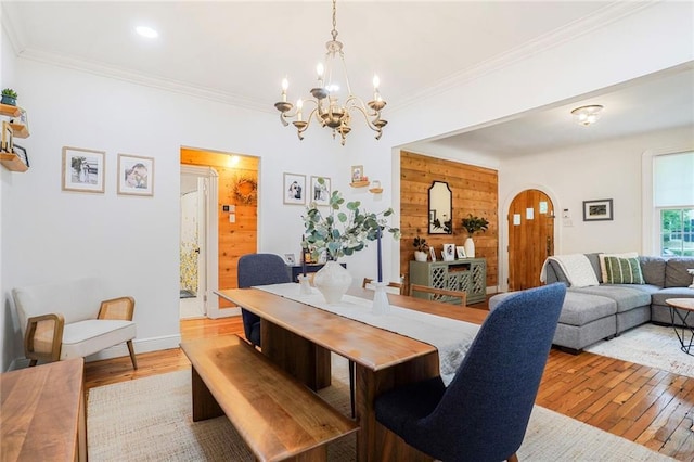 5839 Vicksburg St, New Orleans, LA 70124 - dining room featuring arched walkways, a chandelier, light wood finished floors, and crown molding