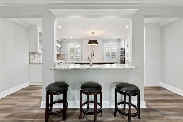 9504 Robin Ln, River Ridge, LA 70123 - kitchen featuring a sink, white cabinetry, dark wood-style floors, a peninsula, and recessed lighting