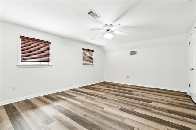 empty room featuring baseboards, wood finished floors, visible vents, and ceiling fan