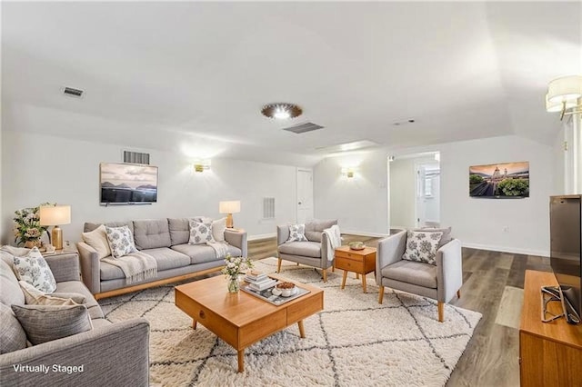 living area featuring wood finished floors and visible vents