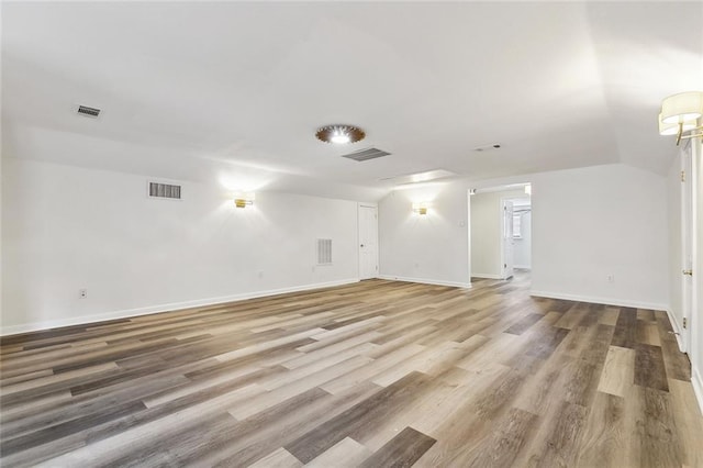 interior space with wood finished floors, visible vents, and baseboards
