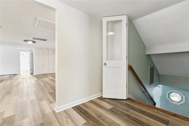 bonus room featuring attic access, vaulted ceiling, wood finished floors, and visible vents