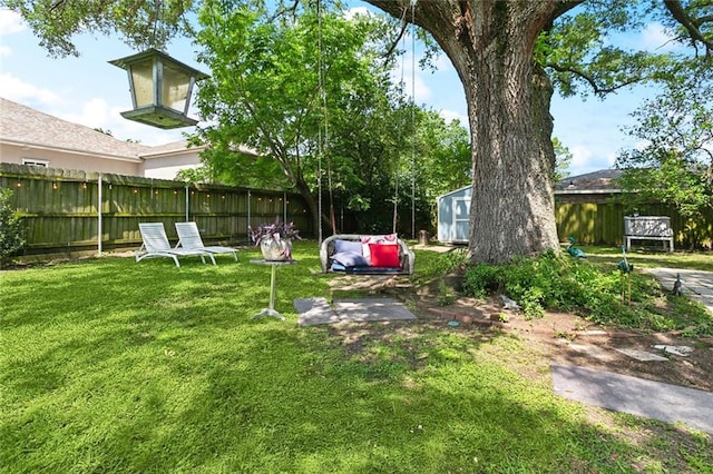 view of yard with a fenced backyard, an outdoor structure, and a storage shed