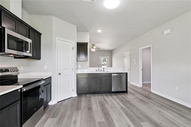 524 Helis Dr, Waggaman, LA 70094 - kitchen with appliances with stainless steel finishes, light countertops, light wood finished floors, a ceiling fan, and a peninsula