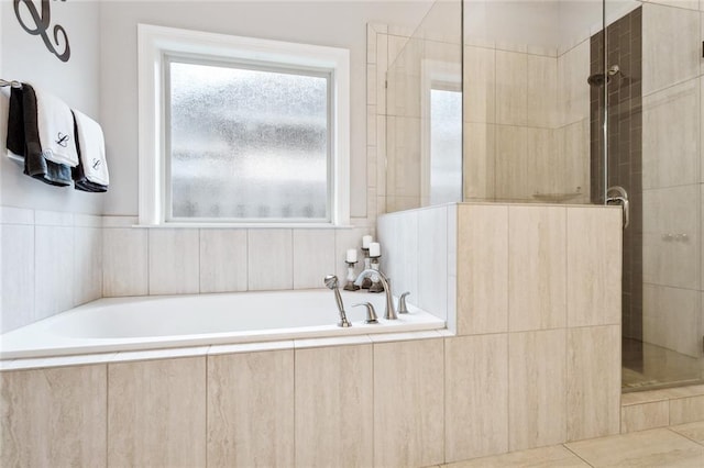 bathroom featuring a garden tub, a stall shower, and a wealth of natural light
