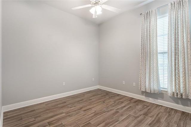 unfurnished room with baseboards, wood finished floors, ceiling fan, and plenty of natural light